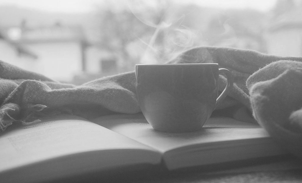 Tasse de café fumante sur un livre ouvert